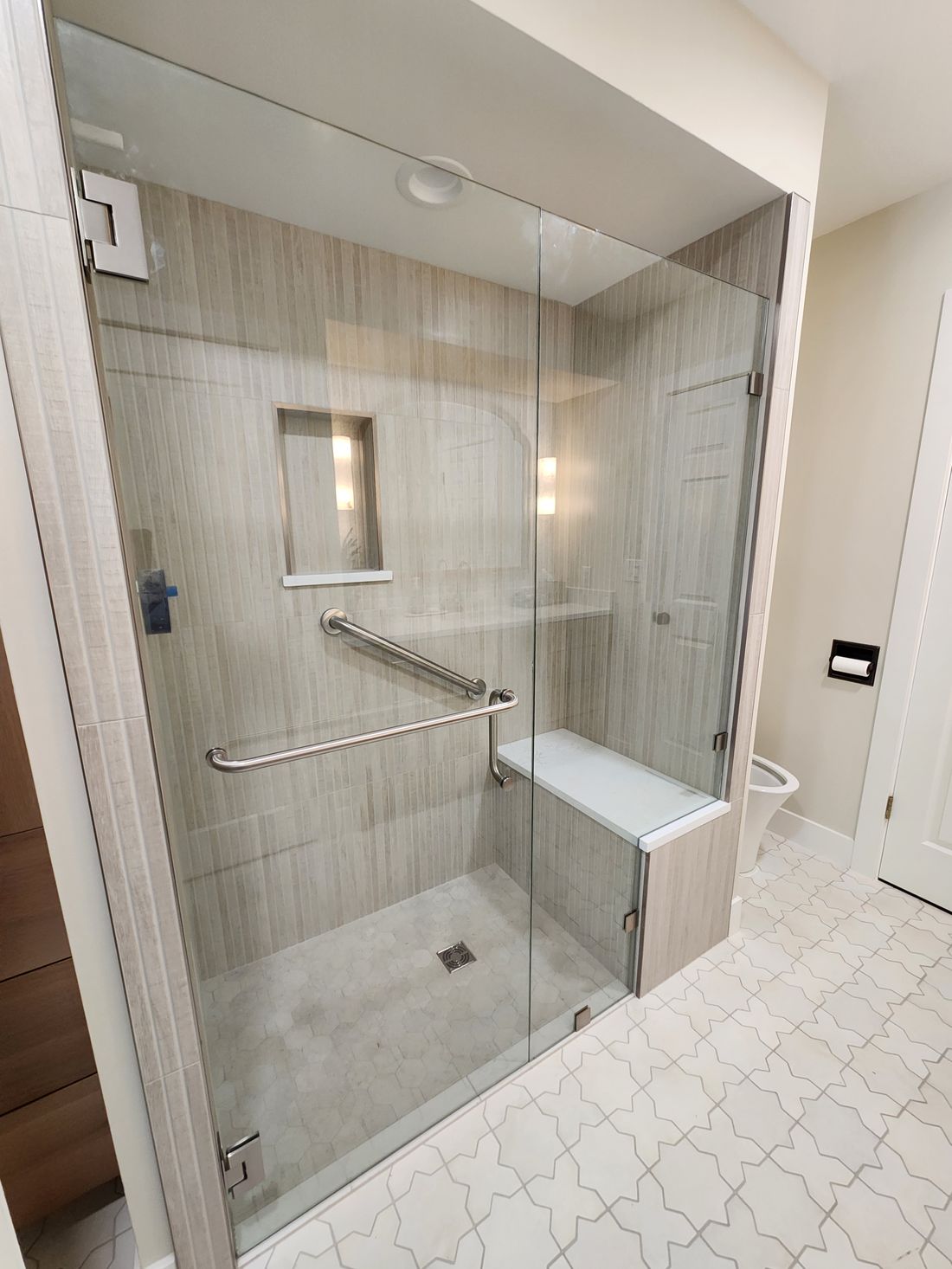Custom glass walk in shower with built in bench by Big Rig Construction